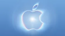 Logo dell'evento che raffigura una mela luminosa su sfondo azzurro, con un bagliore centrale e riflessi arcobaleno lungo i bordi.