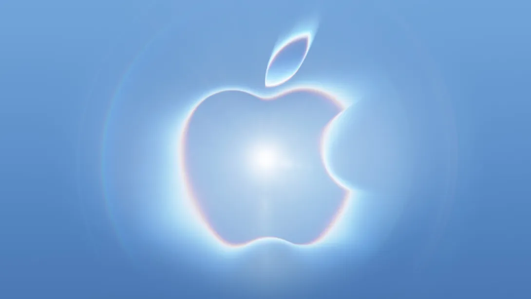Logo dell'evento che raffigura una mela luminosa su sfondo azzurro, con un bagliore centrale e riflessi arcobaleno lungo i bordi.